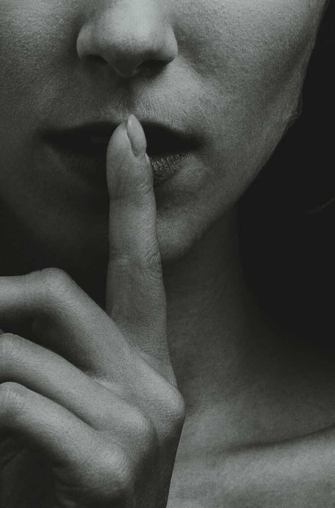 woman holding a finger over closed lips